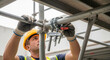 © Cliff - A construction worker performs construction work such as securing single-pipe pipes with clamps on high scaffolding near the ceiling. Close-up.
