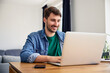 © baranq - Young male student studying at home, using laptop for remote learning