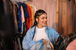© Big Shot Theory - An Excited Young Woman Enthusiastically Shopping for Stylish Clothes in a Trendy Boutique