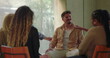 © Marco - Man overwhelmed with emotion in group therapy, sitting with head in hand during intense moment of breakdown and emotional release among supportive peers