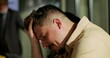 © Marco - Man clutching head in distress after confrontation in modern office, experiencing emotional breakdown, conflict, anxiety, stress, and workplace tension