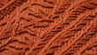 © stockphoto02 - Detailed view of rustic orange knit fabric. Intricate patterns from warm yarn create a cozy, textured surface, highlighting handcrafted details.