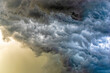 © KURT ROSS - detail of intense dark storm clouds lit from behind with glowing yellow sun light from behind lighting the rain bands