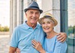 © Vasiliy - Happy senior couple smiling outdoors. Portrait of a mature man and woman in hats embracing. Healthy retirement lifestyle concept