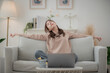 © surachetkhamsuk - Relaxed serene pretty young Asian woman stretching body for relaxing on comfortable sofa enjoying rest in modern living room.