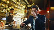 © stockbusters - Drunken man smoking cigarette alone bar counter closeup. Depressed guy drinking