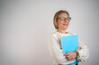 © Nenad - Image of attractive elegant businesswoman holding clipboard in office