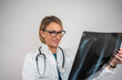 © Nenad - Confident female doctor examining chest X-ray on isolated background