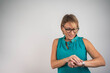 © Nenad - Business woman checking wristwatch on isolated background