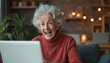 © miss irine - Elderly woman with white hair reacts joyfully to laptop screen. She smiles wide while looking at the computer, possibly receiving good news or winning a game online.