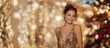 © tetxu - Glamorous and happy woman celebrating at a party with a gold background. Smiling model in a gold sequined dress. New Year's Eve celebration concept.