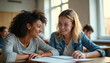 © miss irine - Two young women diverse ethnicities laugh together in classroom. Friends study side by side at desks with notebook. Students share learning in college environment.