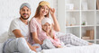 © Pixel-Shot - Happy parents and their little daughter with sleeping masks sitting in bedroom