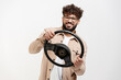 © Maria Vitkovska - Happy man driving a car with a steering wheel, smiling at the camera