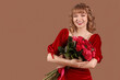 © Pixel-Shot - Beautiful young woman with bouquet of red roses on brown background. Valentine's Day celebration