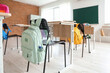 © Pixel-Shot - Backpack on chair in empty classroom