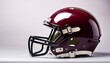 © Aidan - side view of maroon american football helmet with black faceguard and chin strap on plain background