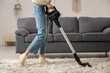 © Pixel-Shot - Young woman cleaning carpet with vacuum cleaner at home
