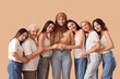 © Pixel-Shot - Group of beautiful women hugging on beige background. Women's History Month