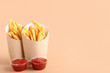 © Pixel-Shot - Paper boxes with tasty french fries and ketchup on orange background