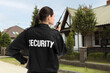 © New Africa - Security guard using radio near house outdoors. Private property protection