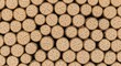 © Ayahe Stock - Neatly stacked firewood logs display warm tones and circular grain patterns in organized symmetry.