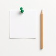© Artcuboy - Flat lay blank white paper note with green push pin positioned beside sharpened wooden pencil on pure white background