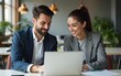 © fu - Two business people using a laptop together in an office. High quality
