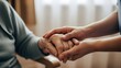 © Said Ali - Closeup of a younger persons hands gently holding the wrinkled hands of an elderly senior citizen, symbolizing care, support, and compassion in a home or care setting