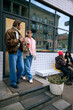 © Lustre Art Group  - Friends chatting with warm drinks near modern cafe on autumn day. Concept of urban lifestyle ads, seasonal communication, event spot ambience, and gentle wellbeing storytelling.