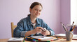 © smth.design - Smiling teenage girl sitting at desk engaging in creative art project with pencils, markers, notebooks, and paintbrushes in a bright room