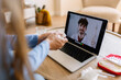 © Xavier Lorenzo - Female patient holding tissue while consulting male doctor online. Sick young woman talking with smiling physician on laptop. Health and remote care concept.