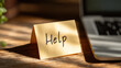 © koranis - Help message on a sticky note sitting on a wooden desk with a laptop