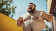 © ArtMajestic - Caucasian overweight bearded man shirtless with large belly shouting and clenching fists outdoors on a sunny day. Overweight Issues, body positivity and confident lifestyle banner with copy space