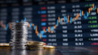 © raseldesigner93 - Stacked silver and gold coins against financial data stock market
