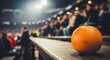 © Skylover - Fresh whole orange resting on stadium railing during sporting event