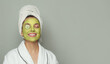 © artmim - Portrait of young woman in green organic cosmetic face mask holding cucumber slices