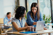 © Suteren Studio - Two Female Startup Team Members Preparing Pitch Presentation Notes at Conference Venue Cafe
