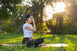 © leungchopan - Young woman doing pranayama breathing exercise outside