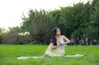 © leungchopan - Woman practicing yoga exercise outdoors at park