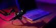 © ronstik - podcast recording, streaming and broadcasting. microphone with laptop on the table in studio with neon lights. banner with copy space
