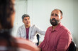 © Marko Geber - Adult men comforting upset peer in group therapy indoors