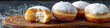 © Tahsin - Close up of powdered sugar donuts with cream filling on a wooden serving board