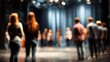 © maxximmm - A group of young artists gathers on a theater stage for a rehearsal, with each artist focusing intently on the instructions given. The stage is set for creativity and collaboration