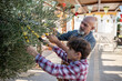 © Antonio Recena - Grandfather and grandson: The 60-year-old man prunes the olive tree while his 10-year-old grandson watches.
