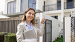© fizkes - Smiling real estate agent with house keys posing outdoors