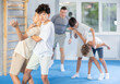 © JackF - Determined teenagers sparring at self-defense training, trying to break free of back grab. Boys practicing basic techniques under guidance of experience instructor....