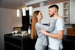 © verona_studio - Couple sharing a moment in their kitchen while preparing breakfast on a weekend morning in a modern apartment setting