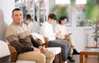 © JackF - Adult man sitting waiting in line on chair at reception