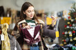 © JackF - Young woman buyer choosing lace lingerie in clothing store decorated for christmas
